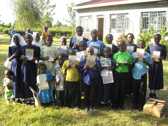 A group of orphans poses with their books and a calander A group of orphans poses with their books and a calander